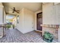 Inviting covered front porch with brick pillars and a ceiling fan at 10749 E Nido Ave, Mesa, AZ 85209