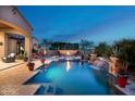 Tranquil backyard oasis with a pool, fire pit, and lush desert landscaping at 11457 E Salero Dr, Scottsdale, AZ 85262
