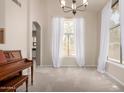 Bright dining room with natural light, neutral walls, plush carpet, and elegant chandelier at 3713 E Encinas Ave, Gilbert, AZ 85234
