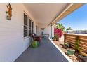 Inviting covered front porch with cozy seating, potted plants, and a view of lush foliage at 5410 E Duncan St, Mesa, AZ 85205