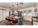 Stylish kitchen featuring stainless steel appliances, pendant lighting, a barn door, and an eat-in island at 5410 E Duncan St, Mesa, AZ 85205
