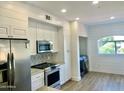 Modern kitchen boasts stainless steel appliances, white cabinetry, and beautiful tile backsplash at 8653 E Royal Palm Rd # 2010, Scottsdale, AZ 85258