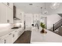 Stunning modern kitchen featuring white cabinets, an oversized island, stainless appliances and stylish pendant lighting at 4746 S Orbit St, Mesa, AZ 85212