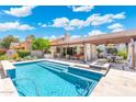 Stunning backyard oasis features a sparkling pool, covered patio, bar, and lush landscaping at 7722 E Hartford Dr, Scottsdale, AZ 85255