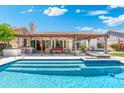 Inviting backyard pool with clear water and a covered patio and bar area for entertaining at 7722 E Hartford Dr, Scottsdale, AZ 85255