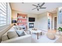 Comfortable living room with a modern ceiling fan, fireplace, and stylish built-in shelves at 1237 E Marcella Ln, Gilbert, AZ 85295