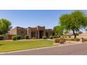 Attractive desert home with manicured lawn, mature trees, and a walkway leading to the inviting front entrance at 19515 E Via Del Palo --, Queen Creek, AZ 85142