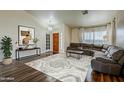 Bright living room features wood floors, a textured rug, and a cozy sectional sofa at 4010 W Mariposa Grande --, Glendale, AZ 85310