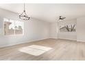 Open living room with light wood flooring and modern light fixture at 1112 E Winged Foot Dr, Chandler, AZ 85249