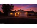 Charming single-story home with a well-maintained lawn and an attached two-car garage, bathed in the warm glow of sunset at 16853 N 39Th Dr, Phoenix, AZ 85053