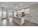 Modern kitchen features an island, white cabinets, granite countertops, and stainless steel appliances at 10305 N 115Th Ave, Youngtown, AZ 85363
