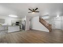 Open-concept living area with wood floors, neutral walls, and staircase at 10551 W Jessie Ln, Peoria, AZ 85383