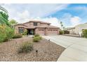 Expansive single-Gathering home with a well-manicured front yard, desert landscaping, and three-car garage at 10653 E Lindner Cir, Mesa, AZ 85209