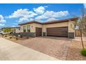 Attractive single story home featuring a brick paver driveway, gated entrance, and a two car garage at 1303 W Cherrywood Dr, Queen Creek, AZ 85140