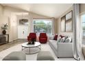 Staged living room with comfortable seating, neutral colors and large arched window for plenty of natural light at 1447 E Nighthawk Way, Phoenix, AZ 85048