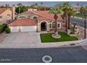 Charming two-story home featuring a three-car garage, arched entry, tile roof, and mature trees at 1457 W Bahia Ct, Gilbert, AZ 85233