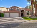 Two-story home featuring a red tile roof, arched entryway, and a spacious three-car garage at 1457 W Bahia Ct, Gilbert, AZ 85233