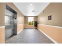 Well-lit hallway with elevator, tile flooring, and a window offering natural light and views at 14575 W Mountain View Blvd # 11315, Surprise, AZ 85374