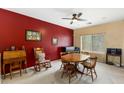 Inviting dining room features red accent wall, natural light, and cozy furnishings for relaxed dining at 16158 W Christy Dr, Surprise, AZ 85379