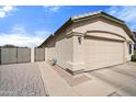 Attached two-car garage with a paved walkway leading to a gated side yard at 20017 N 65Th Dr, Glendale, AZ 85308