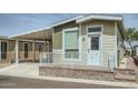 Charming home exterior featuring a covered parking area and a welcoming front porch with white railing at 2206 S Ellsworth Rd # 129B, Mesa, AZ 85201