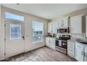 Bright kitchen with white cabinets, stainless steel appliances, and wood-look tile flooring at 2206 S Ellsworth Rd # 129B, Mesa, AZ 85201