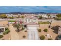 A birds-eye view of the home showcasing the red-tiled roof, landscaping, and mountain views at 30878 W Picadilly Rd, Buckeye, AZ 85396