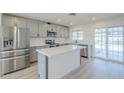 Modern kitchen featuring stainless steel appliances, white countertops, an island, and access to the patio at 3220 E Andorra Dr, Phoenix, AZ 85032