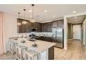 Stylish kitchen with stainless steel appliances, a large island, pendant lighting, and ample cabinet space at 3347 E Outlaw Ln, San Tan Valley, AZ 85140