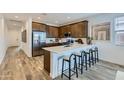 Modern kitchen featuring stainless steel appliances, dark wood cabinets, and a breakfast bar with seating at 38203 N Stillmeadow Rd, San Tan Valley, AZ 85140