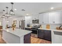 Modern kitchen with white cabinetry, stainless steel appliances, and a large island with quartz countertops at 4025 N 8Th Ave, Phoenix, AZ 85013