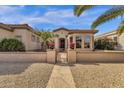 Inviting home entrance with a paved walkway, metal gate, potted plants, and lovely desert landscaping at 4249 E Nightingale Ln, Gilbert, AZ 85298