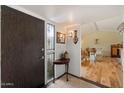 Charming foyer featuring a wood door, decorative table, and view into a light-filled living space at 4800 N 68Th St # 270, Scottsdale, AZ 85251