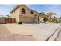Two-story home with a three-car garage, desert landscaping, and a gated side yard at 565 E Rosebud Dr, San Tan Valley, AZ 85143