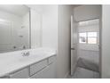 Well-lit bathroom with white cabinetry, a large mirror, and a doorway leading to an adjacent bedroom at 6071 E Artemis Dr, Florence, AZ 85132