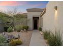 Inviting front entrance with desert landscaping, stone pathway, and a black front door at 6522 E Night Glow Cir, Scottsdale, AZ 85266