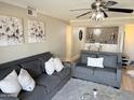 Living room with gray sofas, area rug, and view into dining area at 8260 E Arabian Trl # 275, Scottsdale, AZ 85258