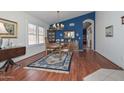 Inviting dining room featuring hardwood floors, a chandelier, and a striking blue accent wall at 9837 W Tonopah Dr, Peoria, AZ 85382