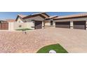 Exterior of home with three car garage, desert landscaping with green grass at 13196 W Coronado Rd, Goodyear, AZ 85395