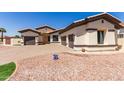 Front exterior of home featuring desert landscaping, driveway and three car garage at 13196 W Coronado Rd, Goodyear, AZ 85395
