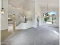 Bright living room with vaulted ceilings, decorative hanging lights, an open staircase, and plush carpet at 1360 E Washington Ave, Gilbert, AZ 85234