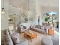 Bright living room with vaulted ceilings, decorative hanging lights, an open staircase, and dining area at 1360 E Washington Ave, Gilbert, AZ 85234