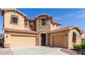 A charming two-story home with a stone-accented entrance, a three-car garage, and a paved driveway at 15620 W Cameron Dr, Surprise, AZ 85379