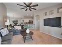 Cozy living room featuring a ceiling fan and an open layout towards the dining area and kitchen at 15834 W Avalon Dr, Goodyear, AZ 85395