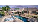 Inviting backyard with pool, spa, desert landscaping, covered patio, and outdoor seating at sunset at 1620 W Nighthawk Way, Phoenix, AZ 85045