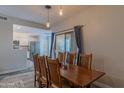 A dining room with a wooden table and chairs, stylish pendant lighting, and sliding glass doors at 16801 N 94Th St # 1010, Scottsdale, AZ 85260