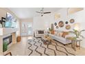 A well-lit living room with a fireplace, white shiplap wall, and tile flooring at 16823 S 8Th St, Phoenix, AZ 85048