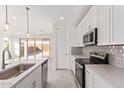 A modern kitchen with stainless steel appliances, white cabinetry and an island overlooking the backyard at 18508 E Dario Rd, Gold Canyon, AZ 85118