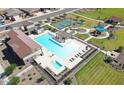 Aerial view of community featuring sparkling pool, playground, tennis courts, and green spaces at 19360 N Diego Way, Maricopa, AZ 85138
