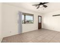 Neutral living room featuring tile flooring, a ceiling fan, and a front door entry at 2019 W Wayland Rd, Phoenix, AZ 85041